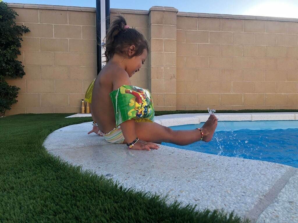 Nina-jugando-en-piscina-con-cesped-artificial.jpg